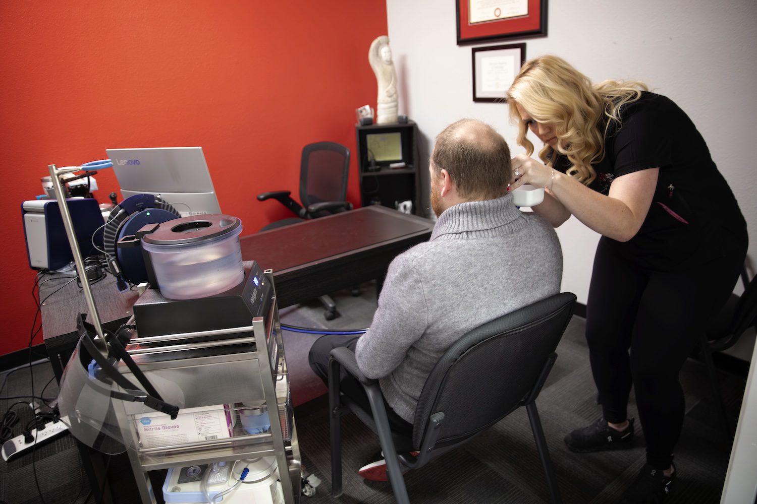 Office(22) Dr. Emily E McMahan of Alaska Hearing & Tinnitus Center demonstrating earwax removal procedure