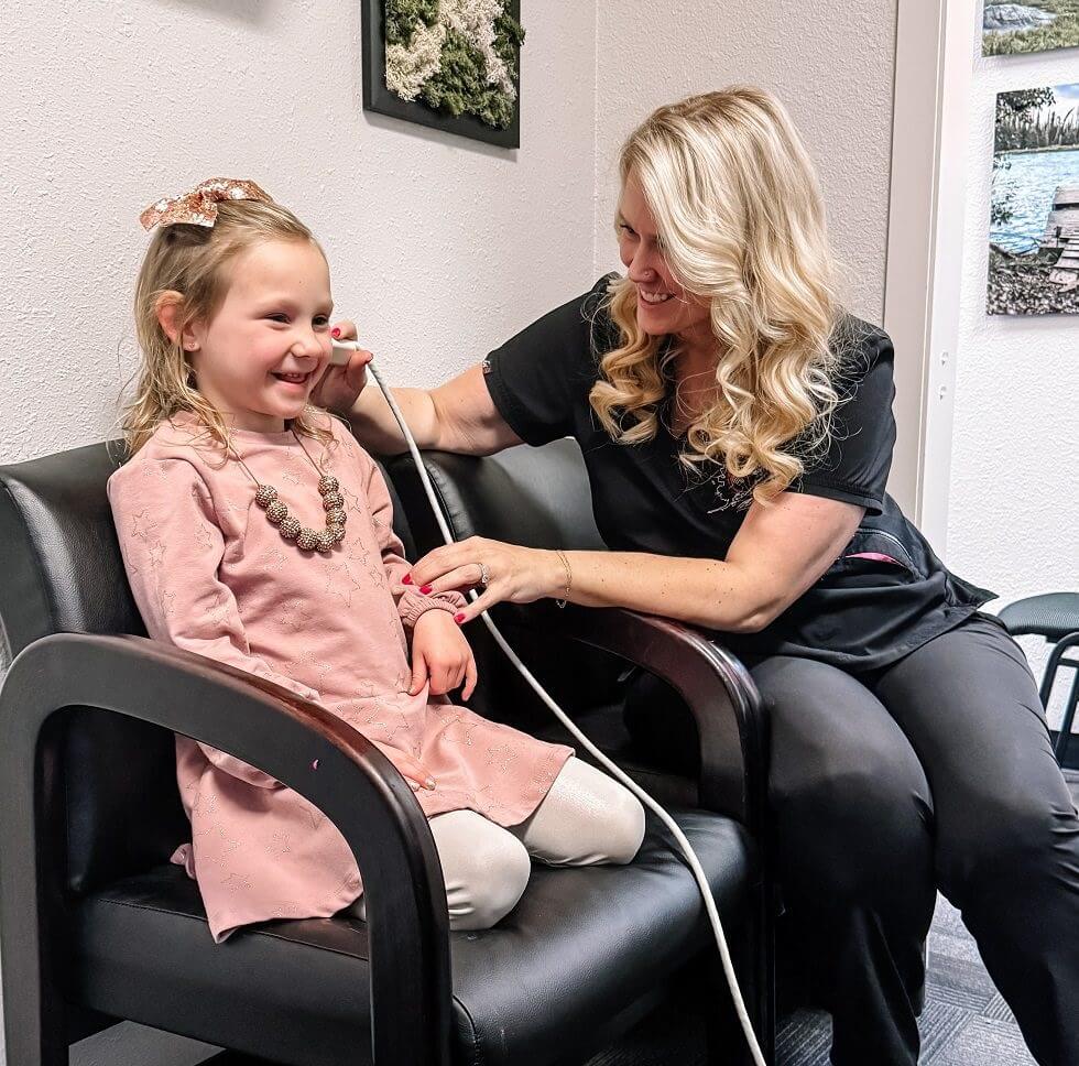 emily-mcmahan-doing-an-ear-check Dr. Emily McMahan Using Earwax Removal Equipment During Appointment