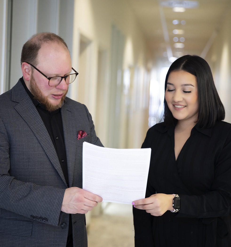 Ashley Oliver holding a document with another staff member