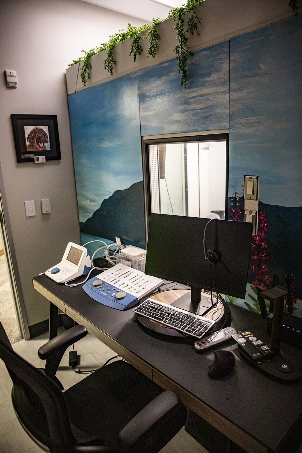 Dr. Emily McMahan Observing Hearing Asssessment Booth During Appointment